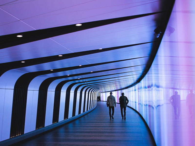 Symbolbild Zukunft des Arbeitens: 2 Männer in einem futuristischen Tunnel